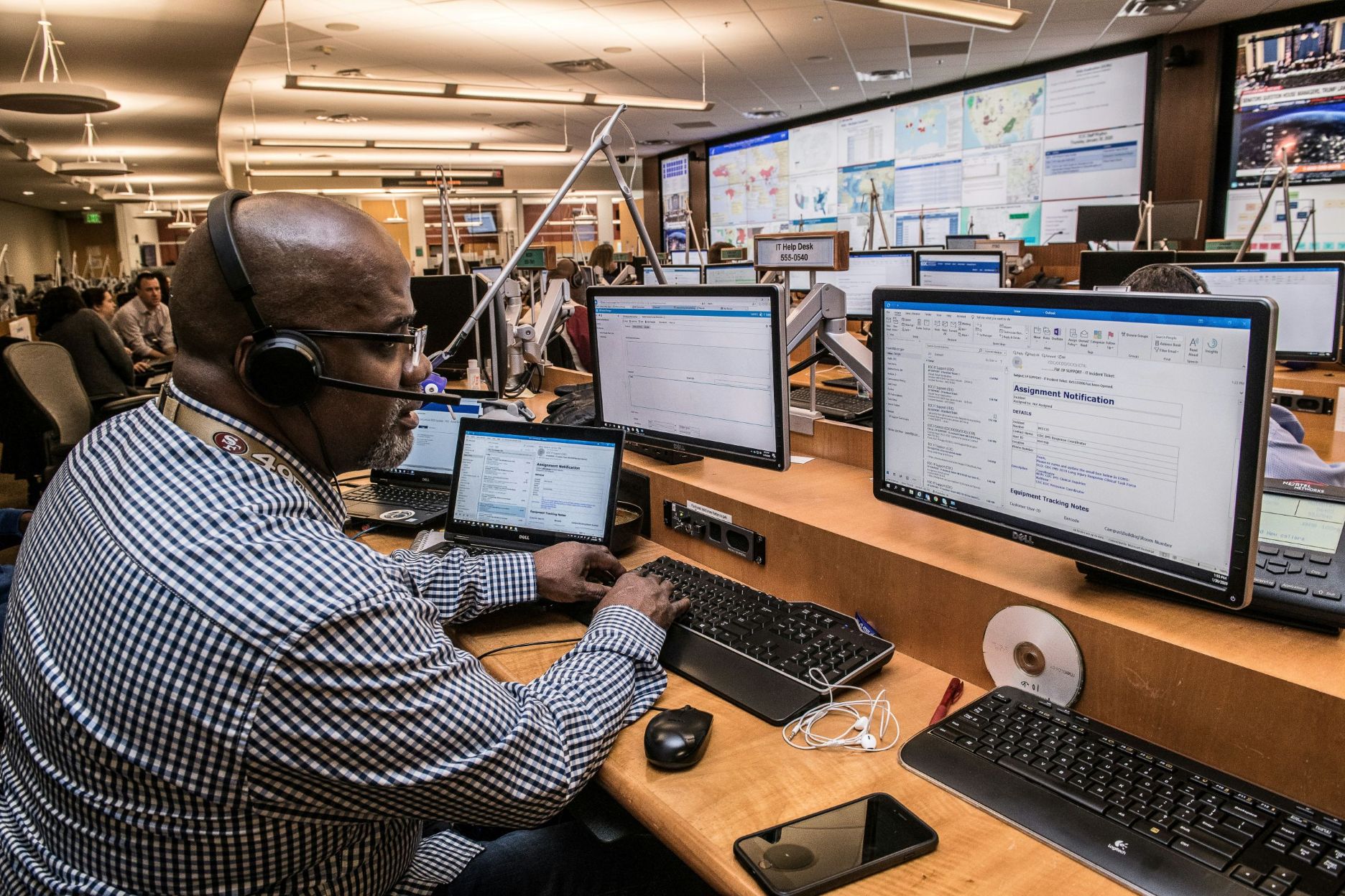 Engineer in control room wearing headphones and a microphone.