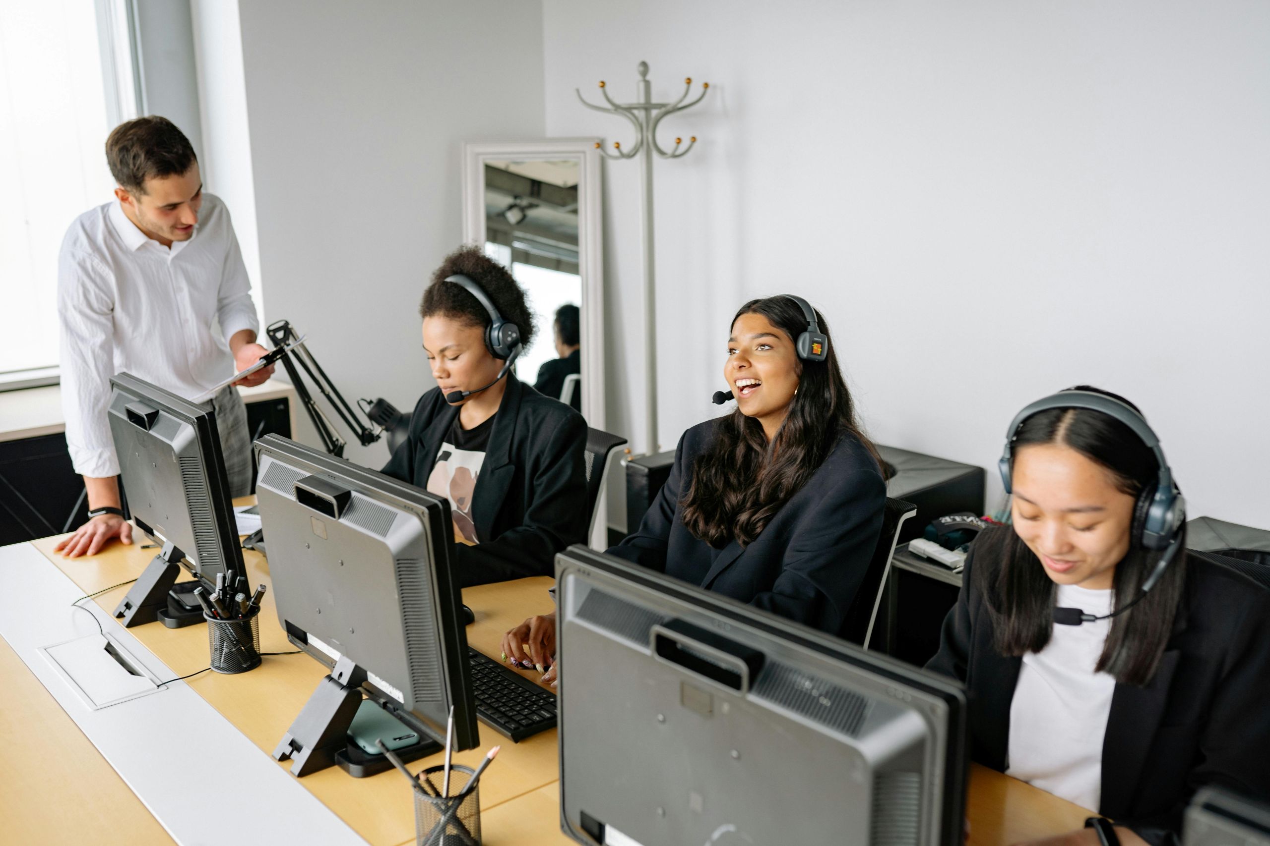 Team of IT professionals wearing headsets working in their stations.